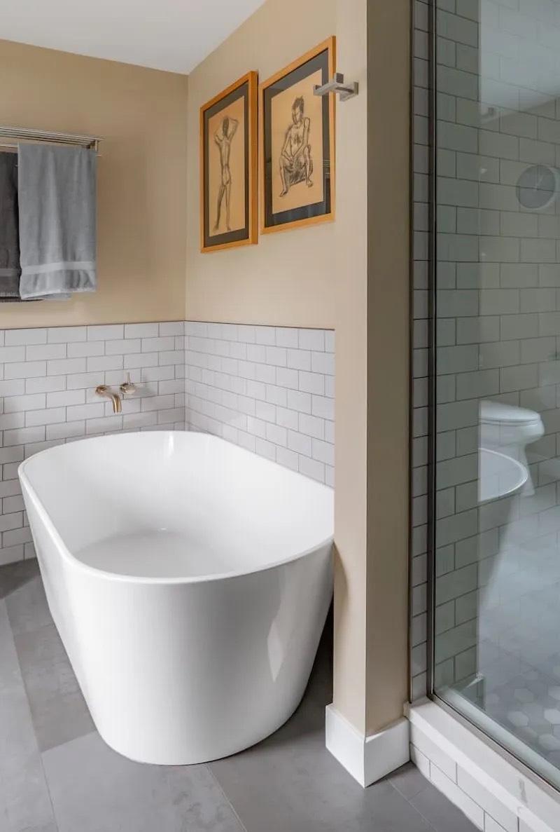 Detail of large-format porcelain floor tile with heated mat and transition to shower in a Seattle primary bathroom