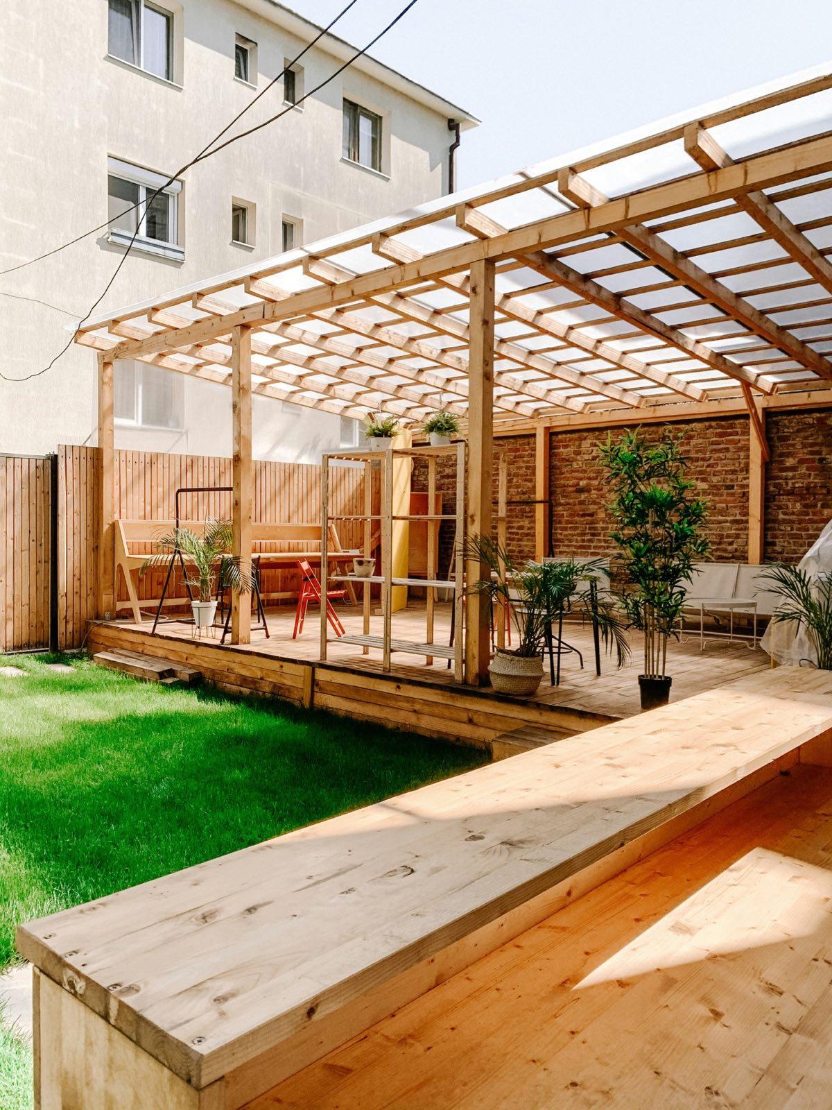 Covered deck with a translucent pergola roof in a city courtyard