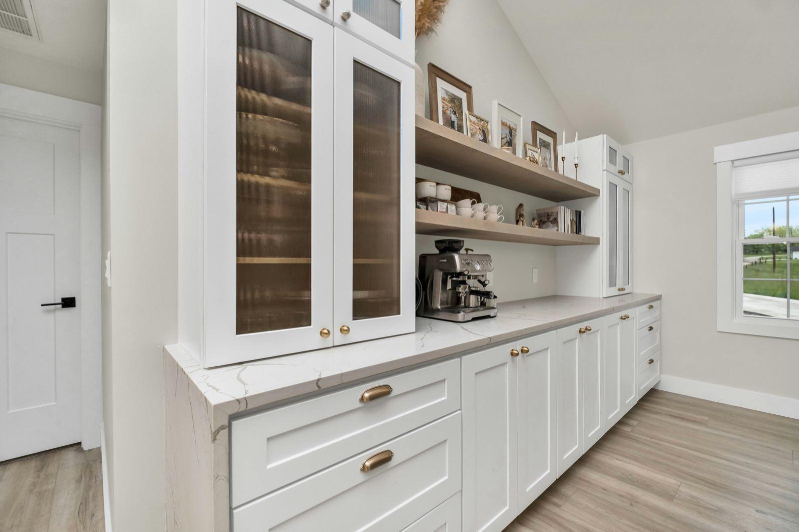 Custom built-in cabinetry with glass-front uppers and open floating shelves