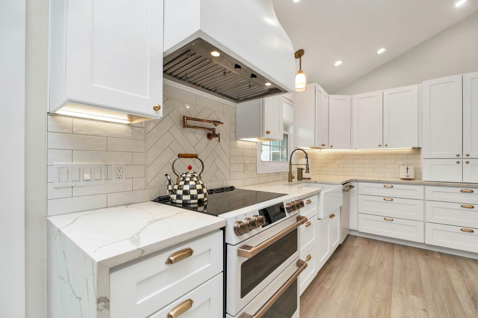 Completed Ballard kitchen range zone with herringbone tile backsplash and under-cabinet lighting