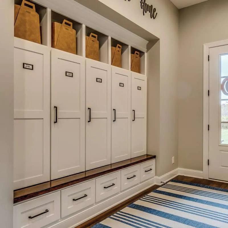 Mudroom built-in with white locker cabinets, wood bench top, drawers, and upper cubbies
