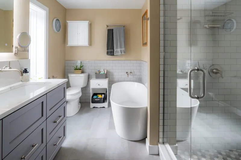 Remodeled Capitol Hill primary bathroom with large-format tile, frameless glass shower, and custom double vanity